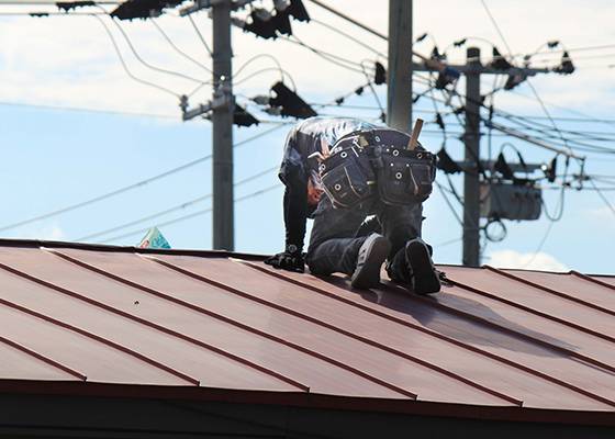屋根の上で作業している人のイメージ